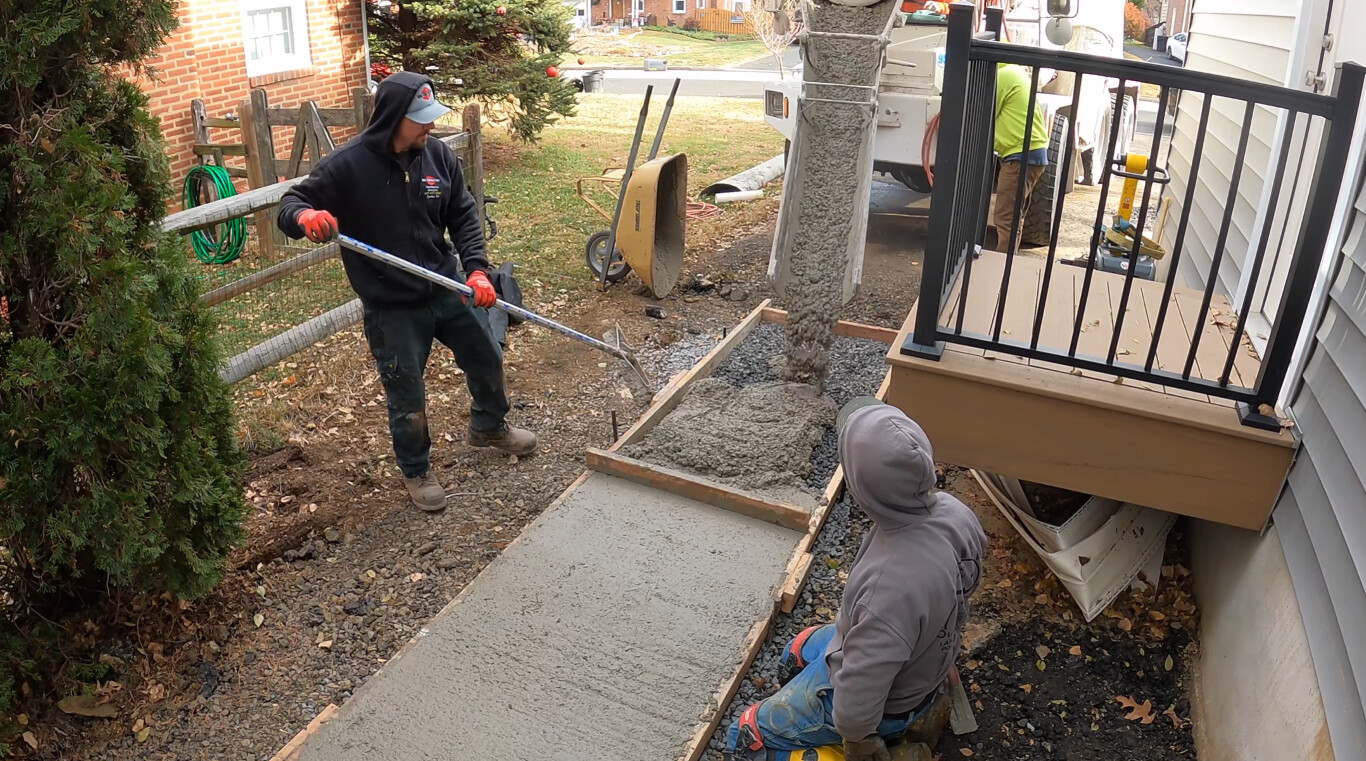 Skilled concrete workers finishing a residential walkway in Blue Springs